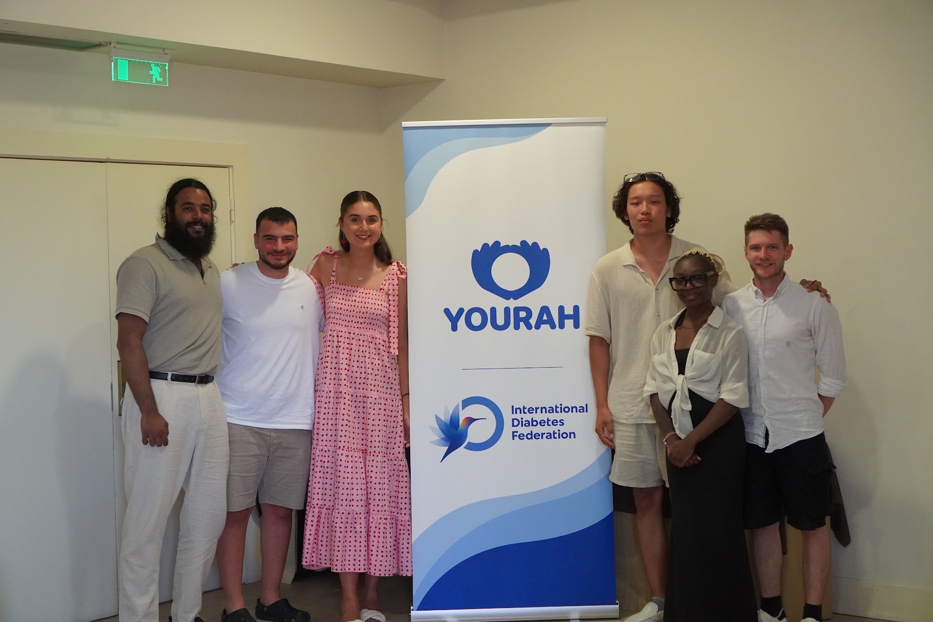 The cgm4all team standing beside a YOURAH and International Diabetes Federation banner